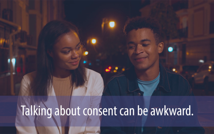 two African American teens sit next to each other in the evening with a darkened city street behind them with text that says 'Talking about consent can be awkward.'